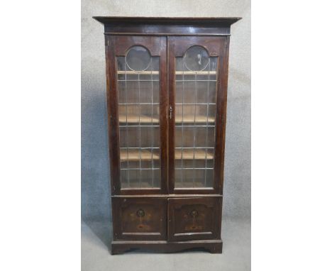 A C.1900 oak library bookcase with leaded glazed doors above panel doors with Art Nouveau inlay. H.185 W.90 D.39CM 