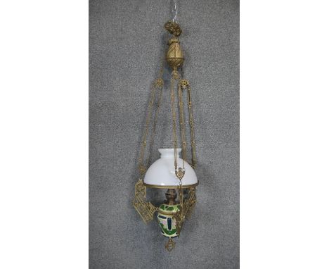 An Art Nouveau gilt metal and ceramic adjustable height oil lamp with weighted fitting. The pierced gilt metal bracket decora