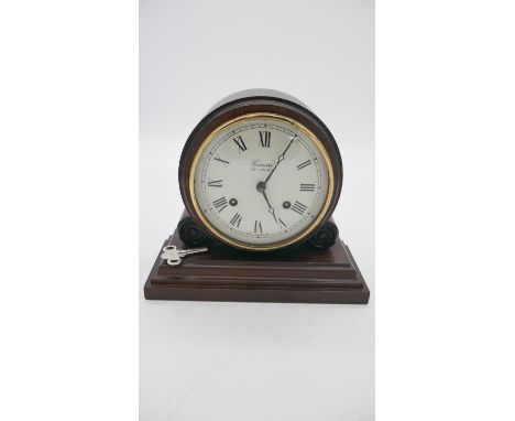 A mahogany vintage mantle clock by Comitti of London, white enamel dial with black Roman numerals. Brass movement. H.21 W.24c
