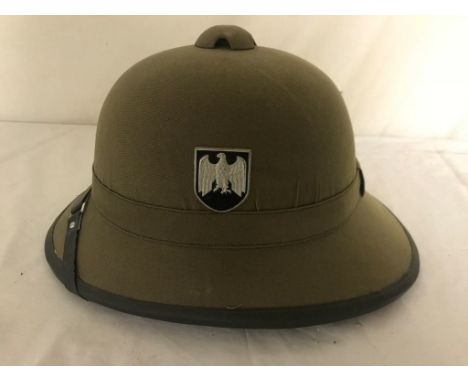 A modern German WWII-style pith helmet and military baseball caps