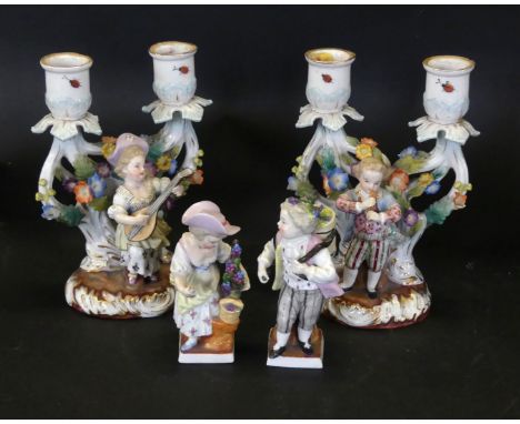 A pair of Continental porcelain candelabras Modelled in the form of a gentleman & lady playing musical instruments before flo