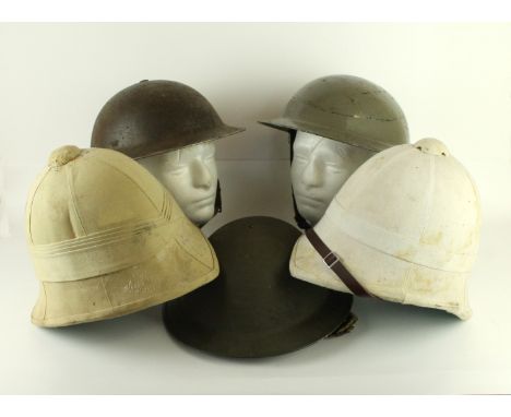 Three WWII period Brodie painted metal helmetsEach helmet complete with liner, two solar pith helmets, together with a vintag