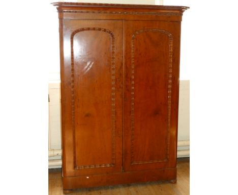 A Victorian mahogany wardrobe With two doors with arched detail, the interior fitted with drawers and hanging space, raised o