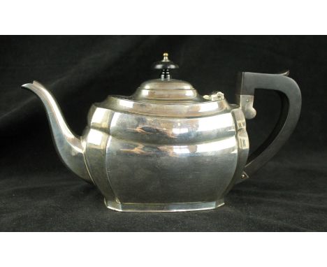 A silver teapotOf plain oval form, with canted corners, the domed lid with a circular ebonised finial and an angular handle, 