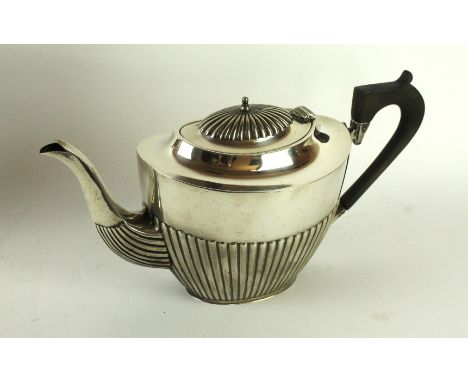 An Edwardian silver presentation teapotOf navette form, with an embossed fluted lower body, with a fluted domed lid, finial d