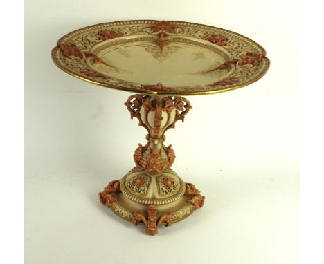 A large Royal Worcester blush ivory pedestal tazzaHaving pierced dished top with gilt highlights and four applied mask heads,