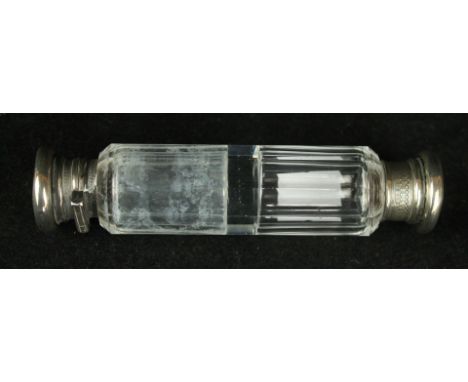 A late 19th Century white metal and cut glass double ended scent bottleOf conventional form, with engine turned lids with vac