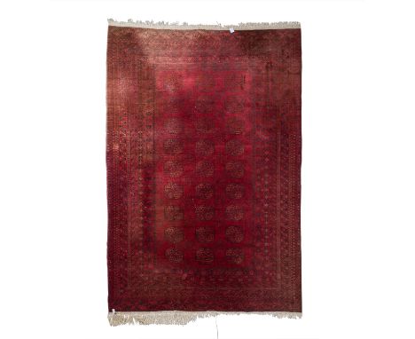 Orientteppich. NORDWEST-AFGHANISTAN, 20. Jh., 296x202 cm. Der dunkelrote Fond des Mittelfeldes ist durchgemustert mit 3x9 Göl