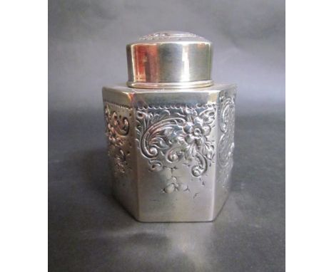 A silver tea caddy of small proportions and hexagonal faceted form, embossed foliage, marks rubbed, 78grams