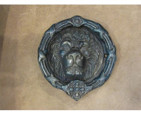 An oversized lion mask cast iron door knocker