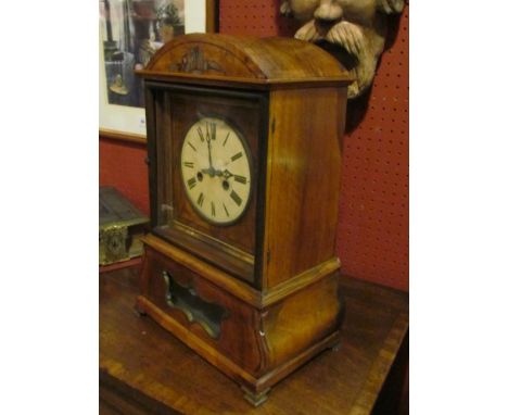 A walnut cased mantel clock with Roman numerals, strikes on a gong 