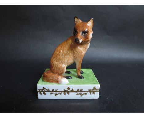An early Crown Derby figure of a seated fox on ceramic plinth