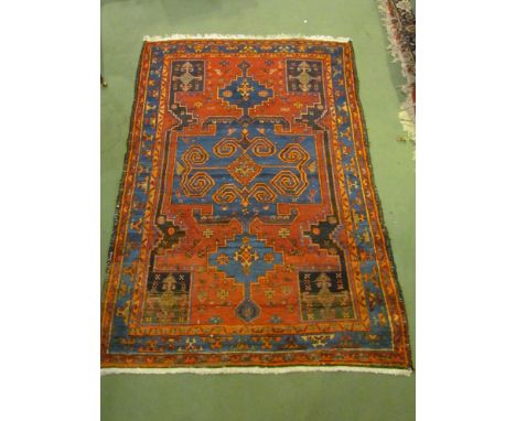 A wool rug, terracotta ground central blue panel, roundels and circular motifs, 195cm x 127cm 