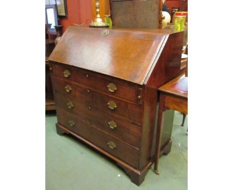 A George III oak bureau, the fitted interior over four graduating long drawers on bracket feet (with key), 101cm long