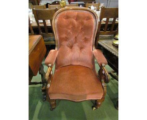 A Victorian button back armchair with scroll arms, salmon velour upholstery with cushion 