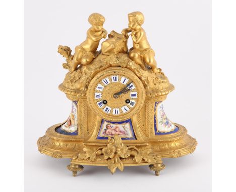 Early 20th century French ormolu and porcelain clock surmounted with two children a carving pilaster on a naturalistic mound,