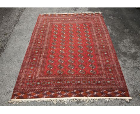 Persian red ground carpet with with five columns of medallions and multiple geometric decorative borders, 315 x 221cm,