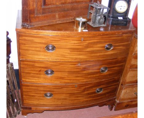 A mahogany bow front chest of three drawers on shaped bracket feet