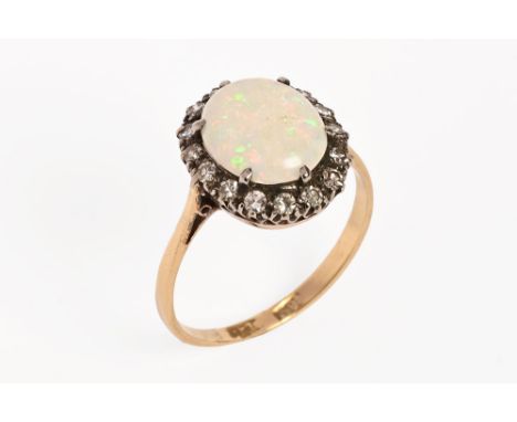 An 18 ct gold opal and diamond cluster ring, the opal surrounded by sixteen diamonds.   CONDITION REPORT:  Weight 2.6 grams. 