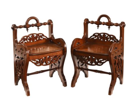 A pair of Victorian mahogany hall chairs, with low fretwork carved backs, solid seats and raised on pierced side supports.  H