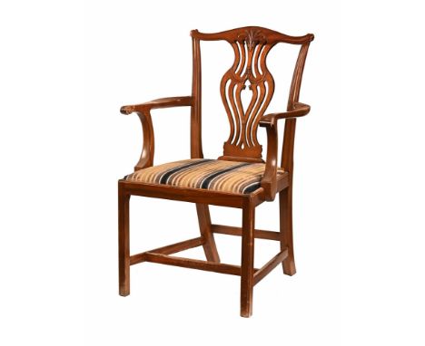 An early 20th century Chippendale style carver armchair, with drop in seat upholstered in striped material and raised on moul