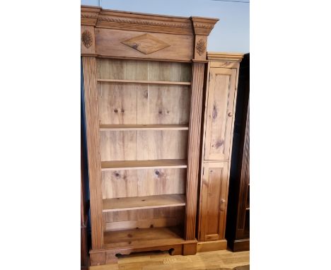 A waxed pine five shelf book case with moulded side panels, 109 x 38 x 207cm and a waxed pine two door narrow cupboard, 32 x 