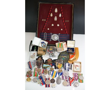 A group of military collectables to include a framed set of Royal Army Ordnance corps badges, a selection of mainly British m