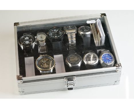 A collection of nine wristwatches contained within a display case to include Casio examples. 