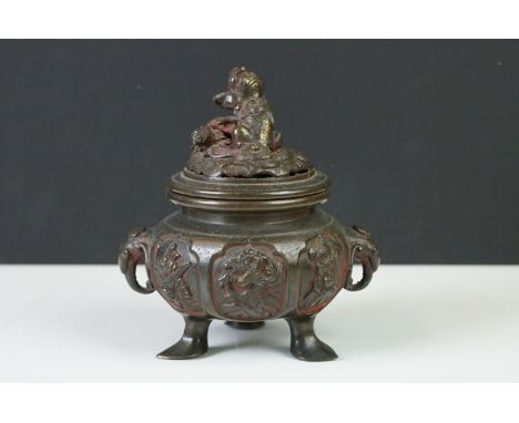 Chinese bronze koro and cover, the pierced lid with a temple dog holding down another creature, the squat body flanked by ele