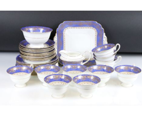 Shelley Part Tea Service decorated with a blue band with gilt pattern on a white ground, comprising 10 Tea Cups, 11 Saucers, 