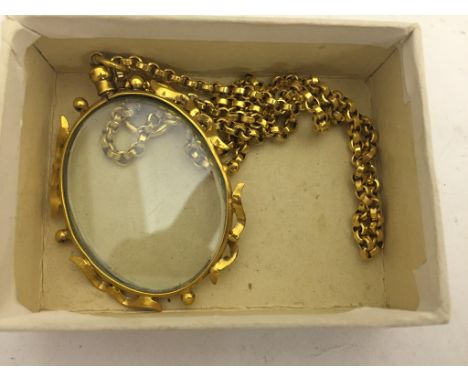 A gold chain with magnifying glass pendant