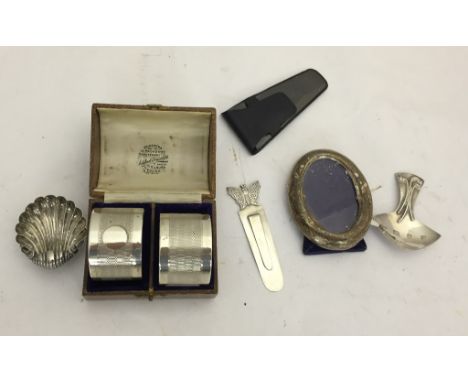 A hallmarked silver caddy spoon, shell, bookmark, napkin rings and photograph frame
