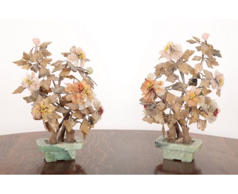 A PAIR OF CHINESE HARDSTONE PLANTS with jade and jadeite flowers on wire and faux wood bound stems, 52cm and 49cm high (2)