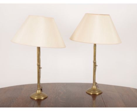 A PAIR OF VICTORIAN BRASS ECCLESIASTICAL EJECTOR CANDLESTICKS with ring turned columns and wide feet, 50cm high, converted to