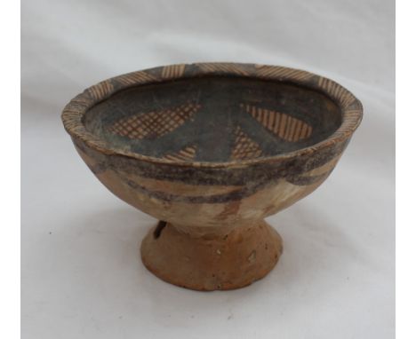 A Chinese Neolithic period primitive pottery bowl, with a flared bowl, painted to the interior with bands and cross hatching 