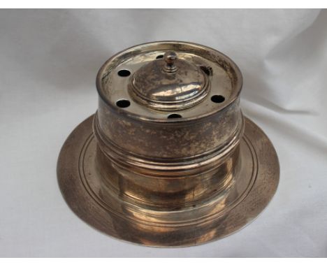 A George V silver desk inkwell, with a domed cover and pen holes, above a cylindrical ring turned body on a spreading foot, L