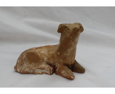 A Chinese pottery dog, laying down with head raised, possibly Yuan dynasty,  15cm long