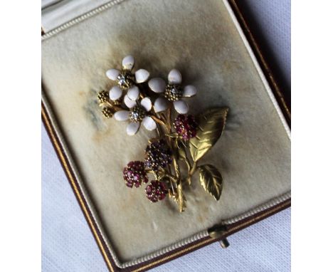 A diamond, ruby. amethyst and enamel decorated brooch, in the form of a sprig of flowers to a yellow metal setting, 5cm long,