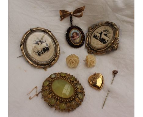 An ivory panel of a stag and hind, mounted in a double sided yellow metal brooch, together with another of horses, other broo