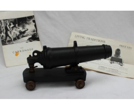 A Carron Company "Carronade" model cannon, on a metal base and brass wheels, 20cm long with a carron company leaflet