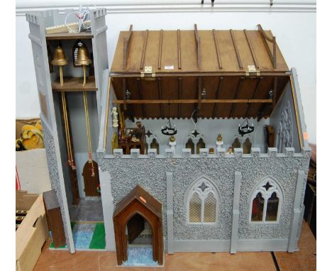 A hand made model of an old style church, complete with figures and accessories, having opening roof and single door to twin 