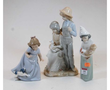 A large Sambo Spanish porcelain figure group, of a young boy in standing pose with his arm around a seated girl with bird upo