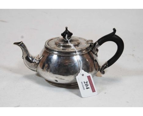 A 1930s silver bachelors teapot, of squat circular form, having ebonised finial and handle. retailed by Mansell of London, we