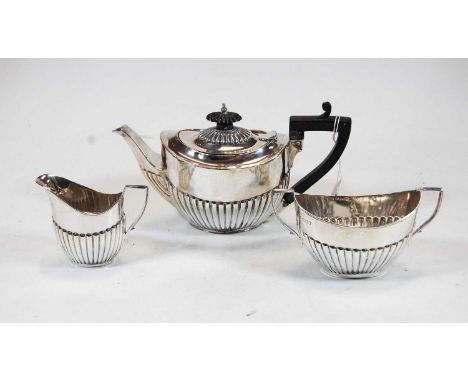 A George V silver bachelors three-piece tea service, comprising teapot, sugar and milk jug, of oval half-reeded form, gross w