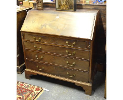 A George III mahogany bureau, the fall enclosing a fitted interior of drawers and niches centred by a cupboard over four long