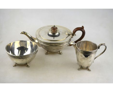 A silver three-piece tea service of hemispherical form with ovoid cream jug, on claw feet, Charles & Richard Comyns, London 1