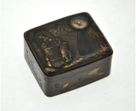 A Japanese rectangular box and hinged cover decorated in gilt with a figure carrying a large sheath of corn with rockwork and