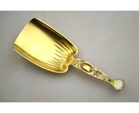 A US sterling silver gilt and enamel caddy spoon with shovel bowl and foliate scroll handle, Whiting Manufacturing, New York 