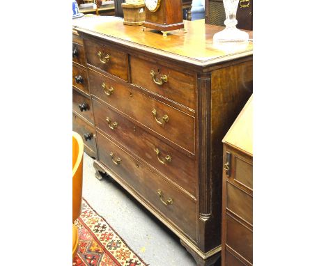 A George III mahogany chest of two short over three long graduated drawers flanked by reeded pilasters, raised on ogee moulde