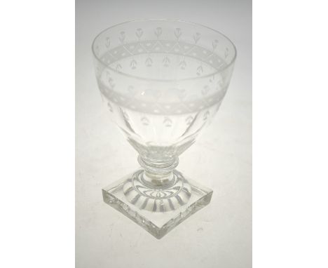 A Regency wine glass, the cut bowl decorated with an etched band and single flowers, short blade knop stem raised on a square